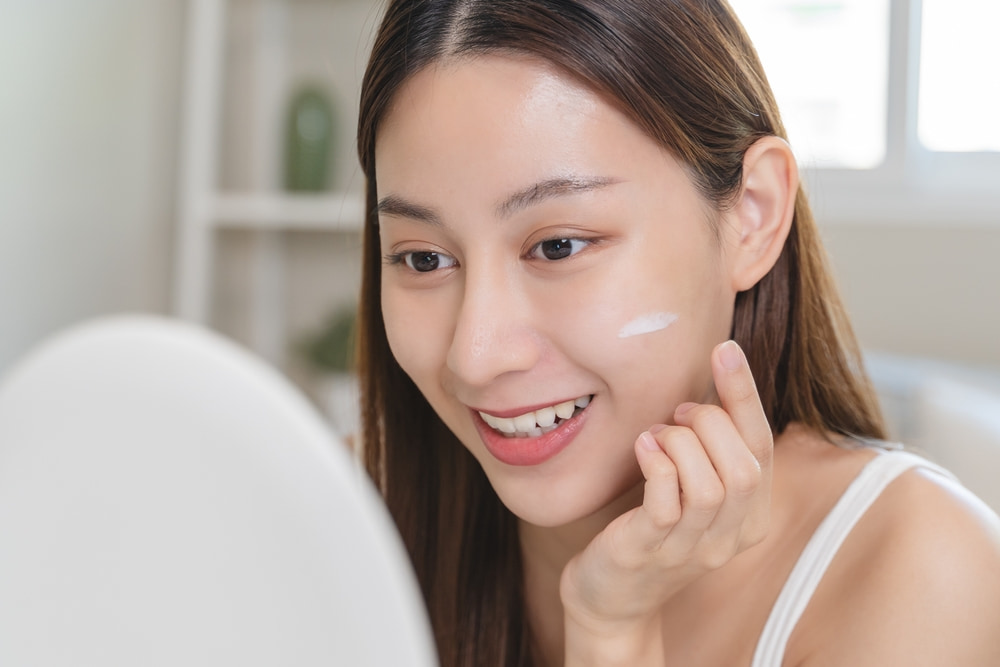 A woman applying cream to take care of face skin problems that have occurred with age