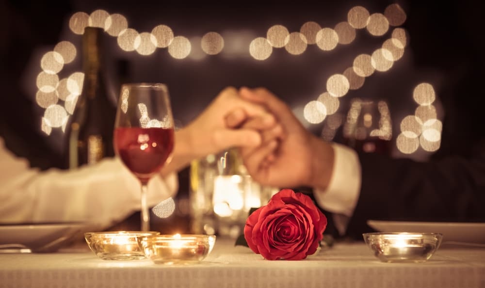 A couple enjoys a romantic Valentine's Day dinner with flowers