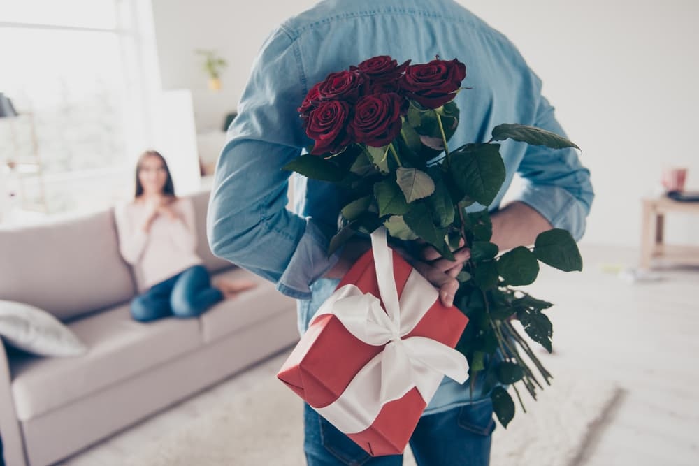 A man surprising his girlfriend with Valentine’s Day flowers